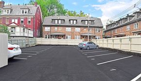 Pittsburgh apartment for rent - a car parked in a parking lot in front of a brick building