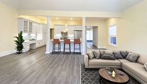 Pittsburgh apartment for rent - a spacious living room with a couch and a coffee table in front of a kitchen with a