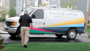 A man walking past a walnut capital van