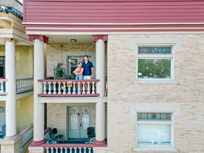 Pittsburgh apartment for rent - A couple is standing on a balcony of a two-story building.