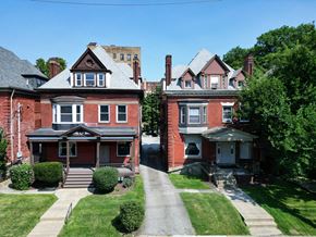 Pittsburgh apartment for rent - Two red brick houses with white trim and windows.
