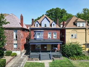 Pittsburgh apartment for rent - A house with a blue roof and a porch.