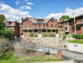 Pittsburgh townhouse for rent - A large red brick building with a green lawn in front.