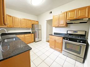 Pittsburgh apartment for rent - A kitchen with wooden cabinets and a black stove top oven.