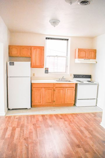 Pittsburgh apartment for rent - A kitchen with orange cabinets and a white fridge.