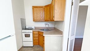 Pittsburgh apartment for rent - a small kitchen with a stove sink and cabinets