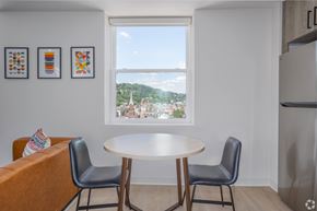 Pittsburgh apartment for rent - A dining room with a table and chairs and a window overlooking a city. at The Jones Tower at the Collective, Pittsburgh, PA 15203