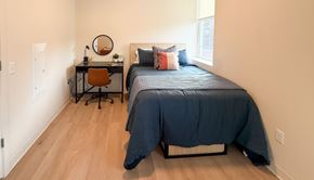 Pittsburgh apartment for rent - A bedroom with a bed, desk, and chair.at The Jones Tower at the Collective, Pittsburgh, PA 15203