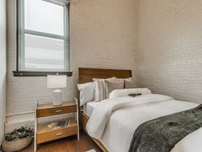 Oklahoma City apartment for rent - A bedroom with a bed, nightstand, and window.