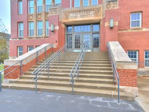 Oklahoma City apartment for rent - A set of stairs lead up to the entrance of a brick building.