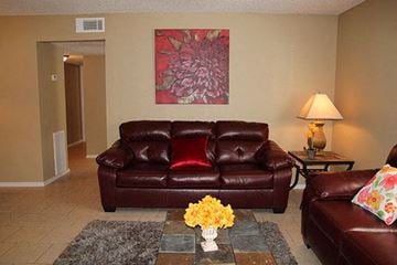 Oklahoma City apartment for rent - a living room with leather furniture and a painting
