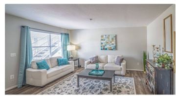 Oklahoma City apartment for rent - A living room with a white couch, a coffee table, and a painting on the wall.