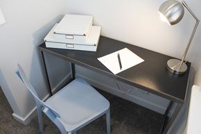 Oklahoma City apartment for rent - a desk with two boxes and a notebook and a chair in a room