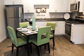 Oklahoma City apartment for rent - an open kitchen and dining area with a table and chairs and a counter top microwave