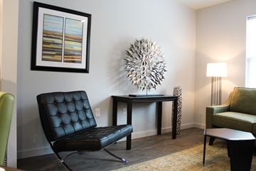 Oklahoma City apartment for rent - a living room with a black leather chair and a table