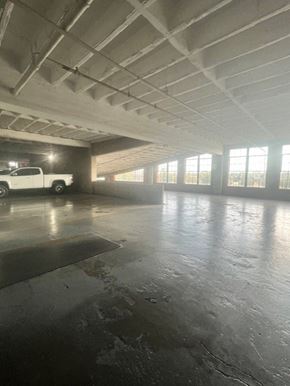 Oklahoma City apartment for rent - A large, empty parking garage with a white truck parked in the background.