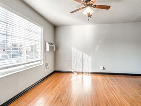 Oklahoma City apartment for rent - an empty living room with wood floors and a ceiling fan