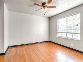 Oklahoma City apartment for rent - the living room of an empty home with wood floors and a ceiling fan