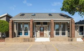 Lawton apartment for rent - A building with a grey roof and brick pillars.