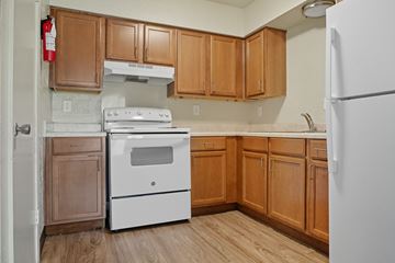 Memphis apartment for rent - A kitchen with wooden cabinets and a white refrigerator.