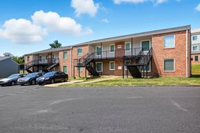 Memphis apartment for rent - A parking lot in front of a brick apartment building with cars parked.