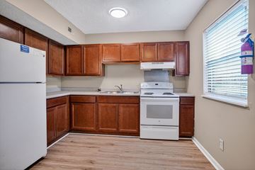 Harrodsburg apartment for rent - A kitchen with wooden cabinets and a white refrigerator.