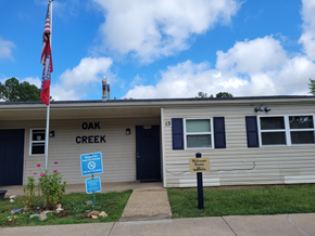 Pocahontas apartment for rent - a white building with an oak creek sign and an flag in front