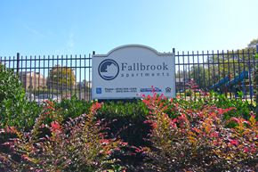 Nashville apartment for rent - a sign for fallbrook apartments in front of a fence and flowers