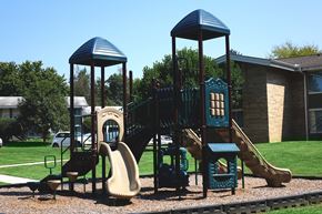Cleveland apartment for rent - a playground with a playset and slides in front of a building