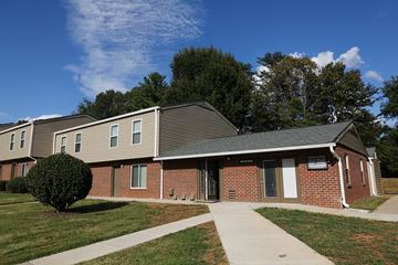Newton apartment for rent - an exterior view of a brick building with a sidewalk