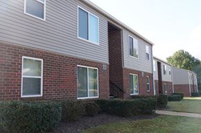 Newton apartment for rent - the side of a brick apartment building with a sidewalk