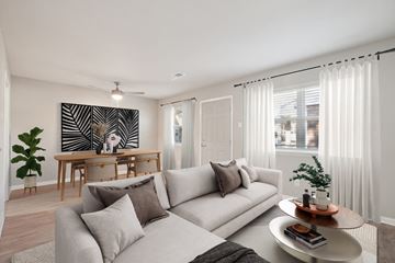 Little Rock apartment for rent - A living room with a grey sofa, a wooden table, and a large painting on the wall.
