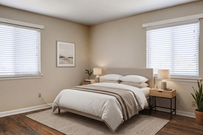Chattanooga apartment for rent - A bedroom with a large bed and a small table with a lamp on it.