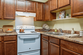Chattanooga apartment for rent - A kitchen with brown cabinets and a white stove.