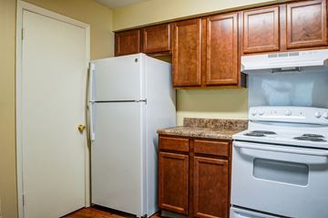 Chattanooga apartment for rent - A white refrigerator stands next to a stove in a kitchen.