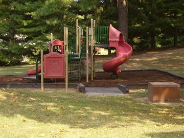 Paris apartment for rent - a playground with a red slide in a park