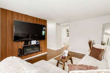 Hilliard apartment for rent - A living room with a white couch and a wooden wall.