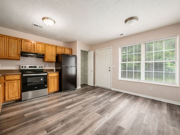 Reynoldsburg apartment for rent - A kitchen with wooden cabinets and a black refrigerator.