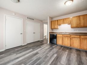 Reynoldsburg apartment for rent - A kitchen with wooden cabinets and a black dishwasher.