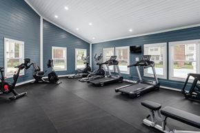 Columbus apartment for rent - A spacious gym with treadmills, exercise bikes, and a bench.