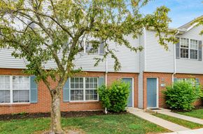 Hilliard apartment for rent - A tree in front of a brick building with blue doors.