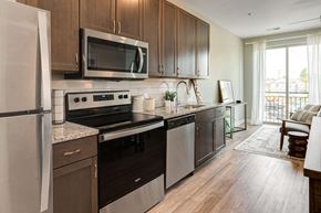 Columbus apartment for rent - a kitchen with stainless steel appliances and wooden cabinets at Adelphi Quarter, Columbus