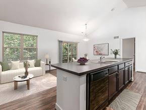 Columbus apartment for rent - A modern kitchen with dark wood cabinets and a white island. at River View at Bexley Apartments, River View at Bexley 43209