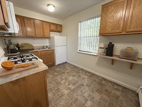 Bowling Green apartment for rent - A kitchen with a white refrigerator and wooden cabinets.