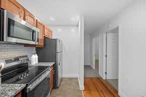 Dayton apartment for rent - A kitchen with a black refrigerator and stove top oven.