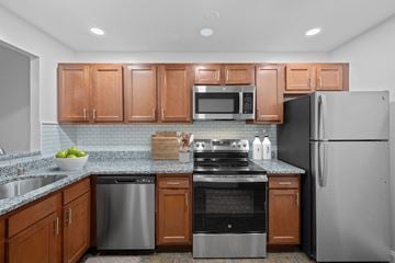 Dayton apartment for rent - A kitchen with wooden cabinets and stainless steel appliances.