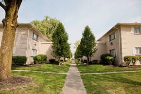 Cincinnati apartment for rent - a walkway between two apartment buildings with grass and trees