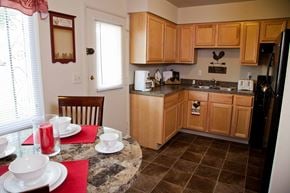 Cincinnati apartment for rent - a kitchen with wooden cabinets and a table and chairs