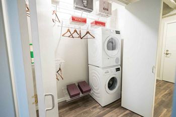 A small laundry room with a washer and dryer stacked on top of each other.