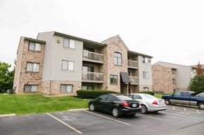 Piqua apartment for rent - an apartment building with cars parked in front of it